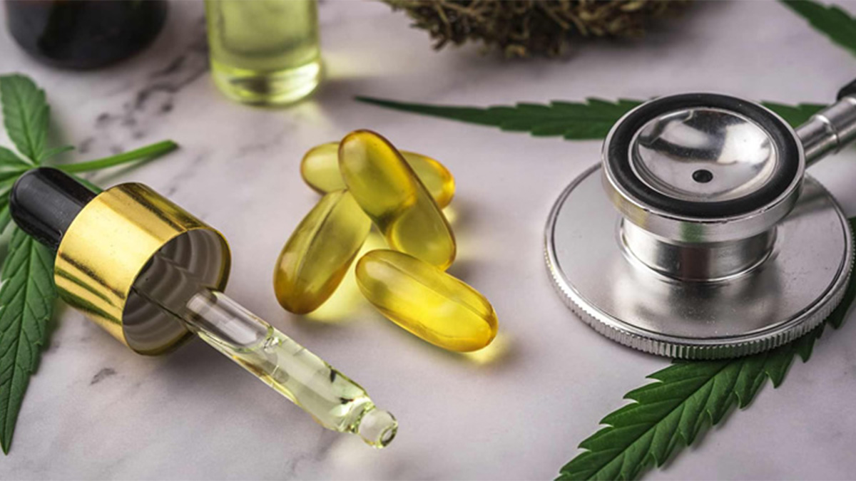CBD capsules and CBD oil with stethoscope and hemp leaf on a table